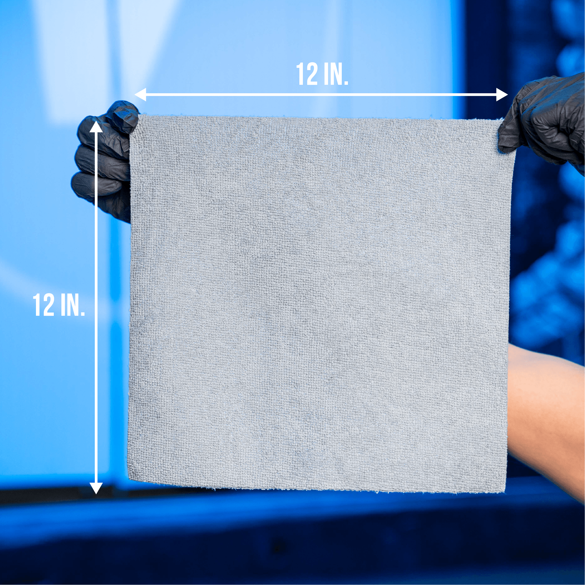 Person holding a 12x12 inch gray VIKING microfiber cloth with black gloves on a blue background