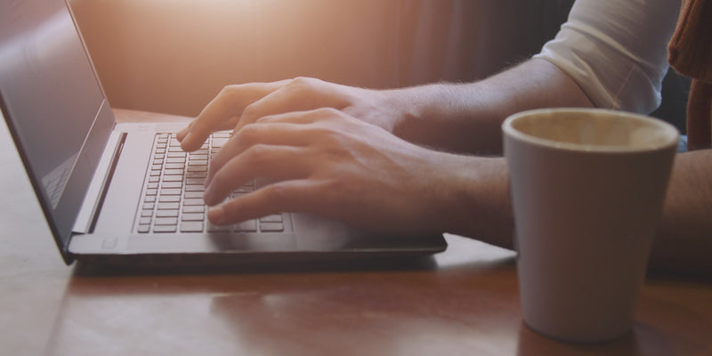 man typing on a laptop